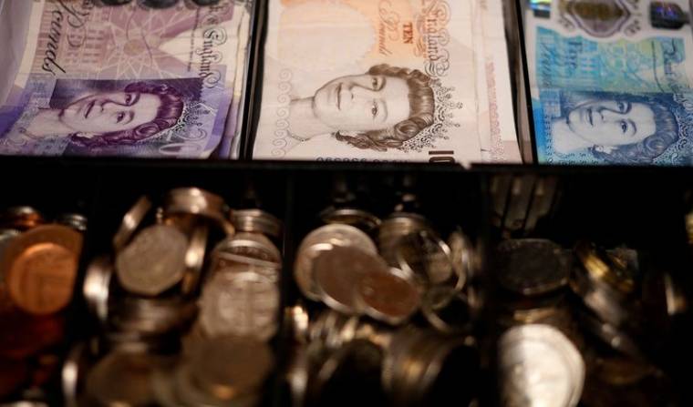 Des billets et des pièces de monnaie en livres sterling dans une caisse enregistreuse à Manchester, en Grande-Bretagne