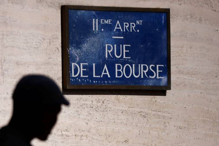 Un homme passe devant la plaque de rue de la Bourse, près du Palais Brogniard, à Paris.