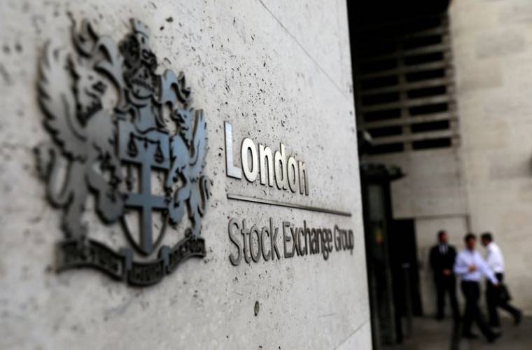 Des piétons sortent et entrent à la Bourse de Londres